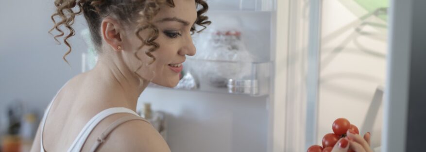 Woman in front of an opened refrigerator